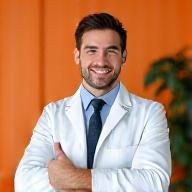 A male registered dietitian, Mark Johnson, giving a thumbs up in a modern office setting.